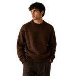 Front view of a male model wearing a dark brown chunky crew-neck knit pullover sweater on a white background for product display