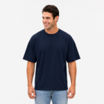 Smiling male model wearing a custom navy blue drop shoulder oversized t-shirt by Eco Jersey, paired with light blue jeans, showcasing the relaxed fit and wide dropped shoulder seam