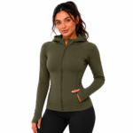 Female model wearing a custom olive green compression hoodie by Eco Jersey, featuring a full-zip front, fitted athletic silhouette, thumb holes, side pockets, and attached hood, paired with black leggings