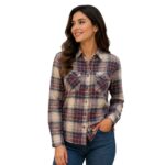 Smiling woman wearing a custom flannel plaid shirt by Eco Jersey in a red, blue, and cream check pattern, paired with blue jeans, showcasing the casual and comfortable fit