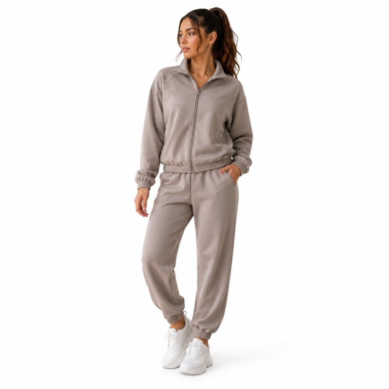 Front view of a female model wearing the super soft women's velour tracksuit in beige with zip-up mock-neck hoodie and tapered jogger sweatpants for fit and style reference