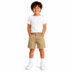 Smiling young boy wearing khaki denim shorts with a white t-shirt and white sneakers on a clean white background