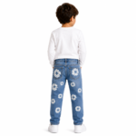 Back view of a young boy wearing blue distressed denim jeans with white daisy floral patch embroidery on back pockets and legs, white long-sleeve top, and white sneakers on a transparent background