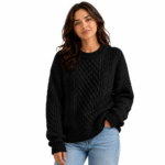 Female model wearing a black cable-knit sleeveless women's pullover sweater in a product lifestyle shot showing colour and fit for the knitwear colour option