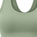 A close-up of a sage green sports bra against a white background, highlighting the smooth fabric and flatlock stitching along the straps and underbust.